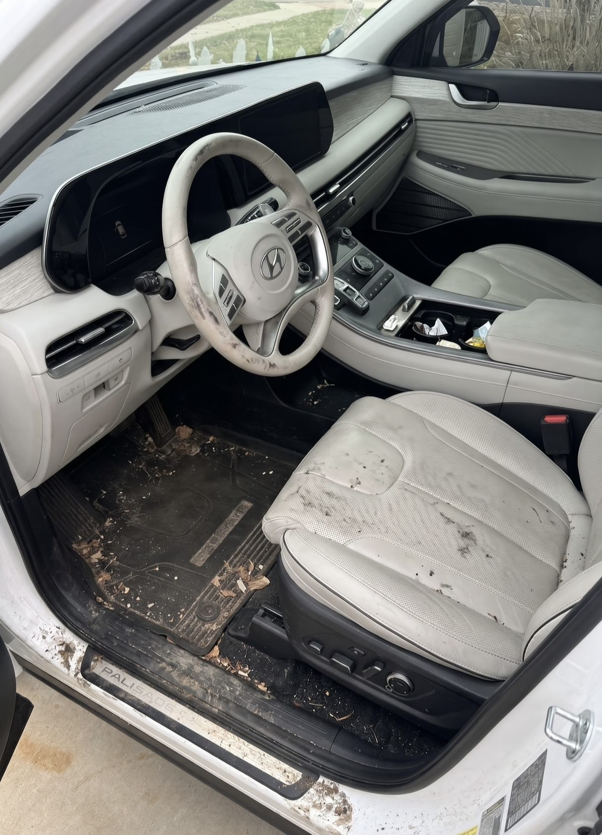 2023 Hyundai Palisade interior before detailing, with dirt and debris on the floor mat and seat